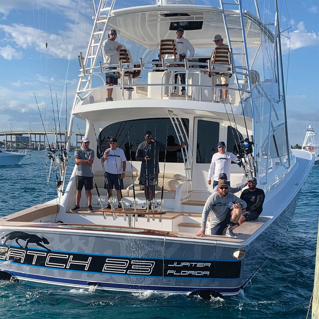 A fishing team stands on the deck on boat deck.