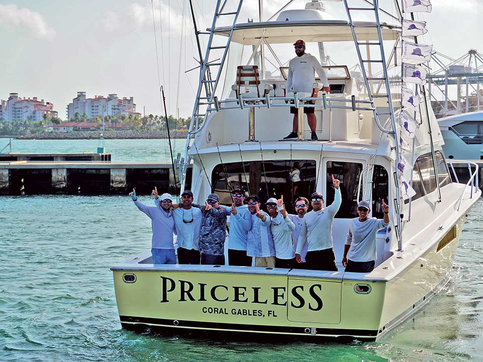 A sport-fishing team stands in the cockpit celebrating their tournament win.