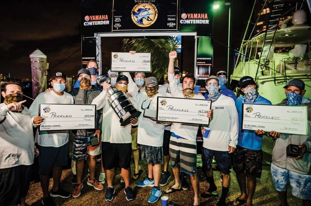 A sport-fishing team stands and celebrates their win at the Miami Billfish Tournament.