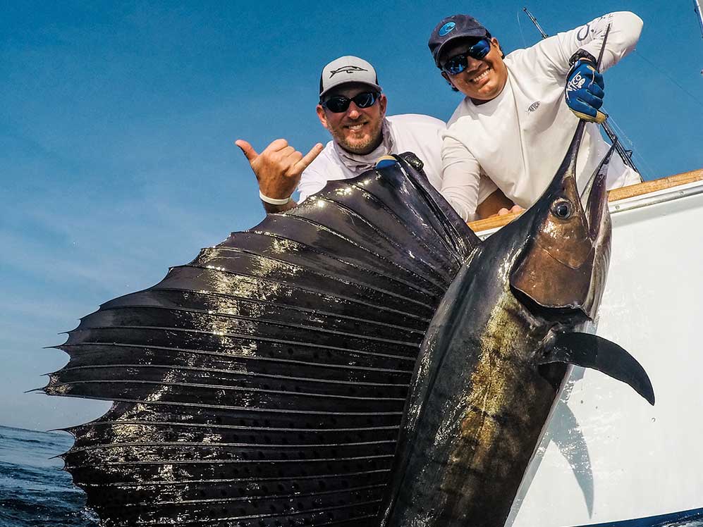 two anglers holding up a pacific sailfish