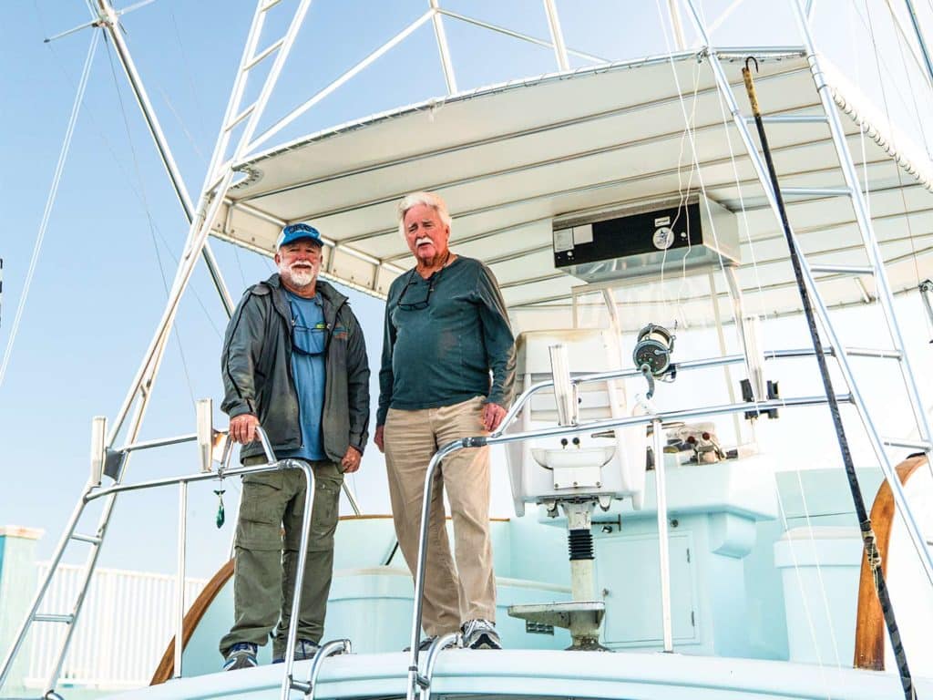 Two men standing on a boat deck.