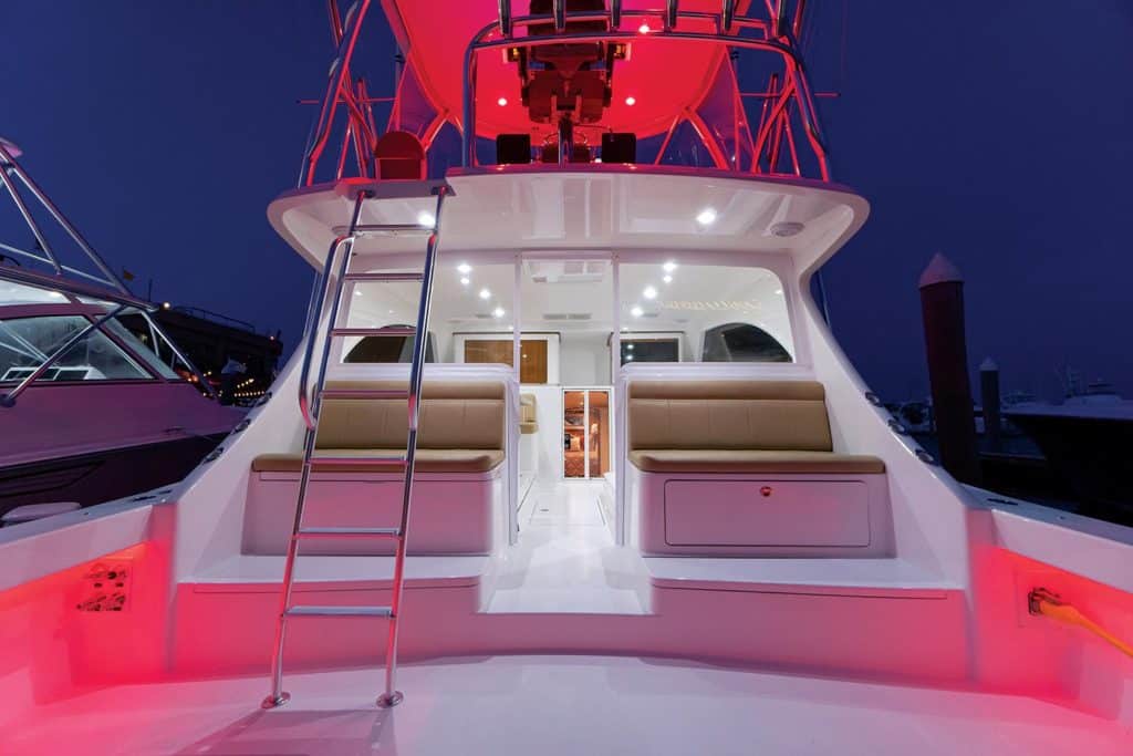 Exterior deck and mezzanine of the Viking 46 Billfish lit up at night.