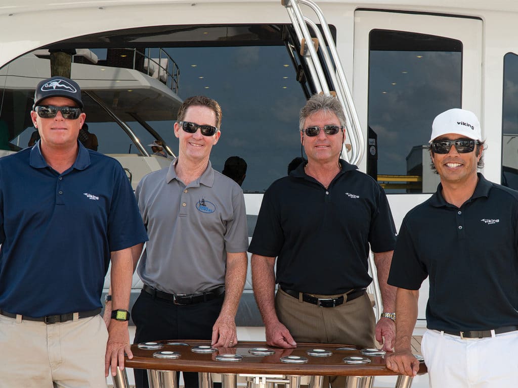 four boat captains standing around on a boat deck.
