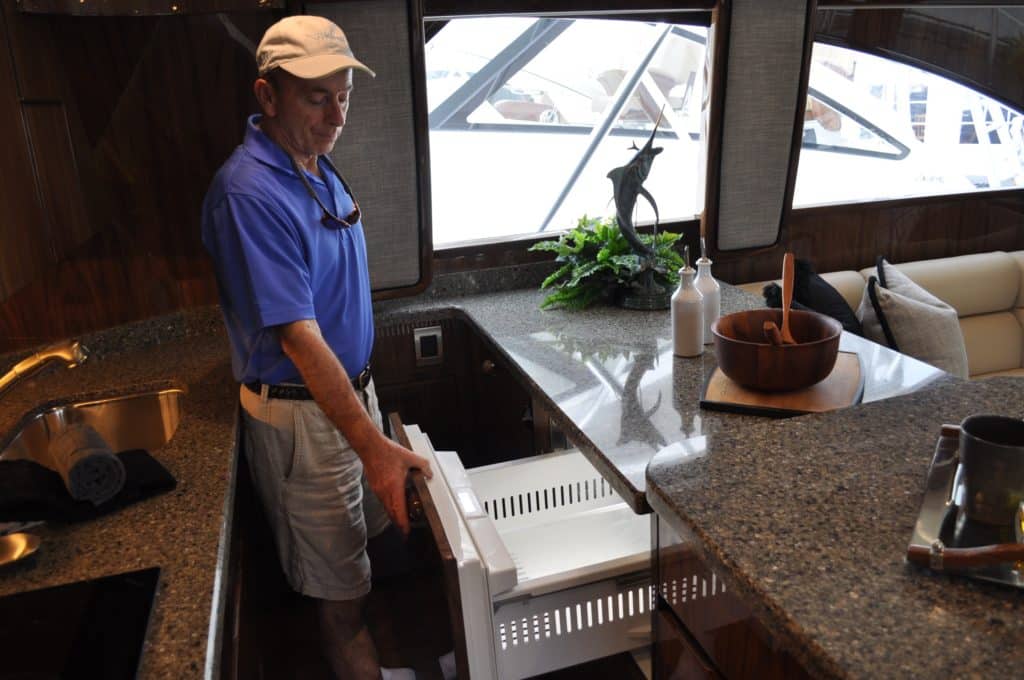 Viking's director of communications, Peter Fredriksen, shows the boat's freezer and refrigerator capacity, which can be customized to fit the owner's needs.