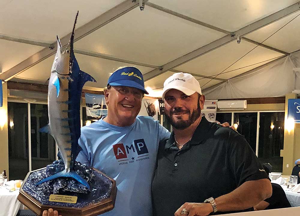 two fisherman holding marlin trophy