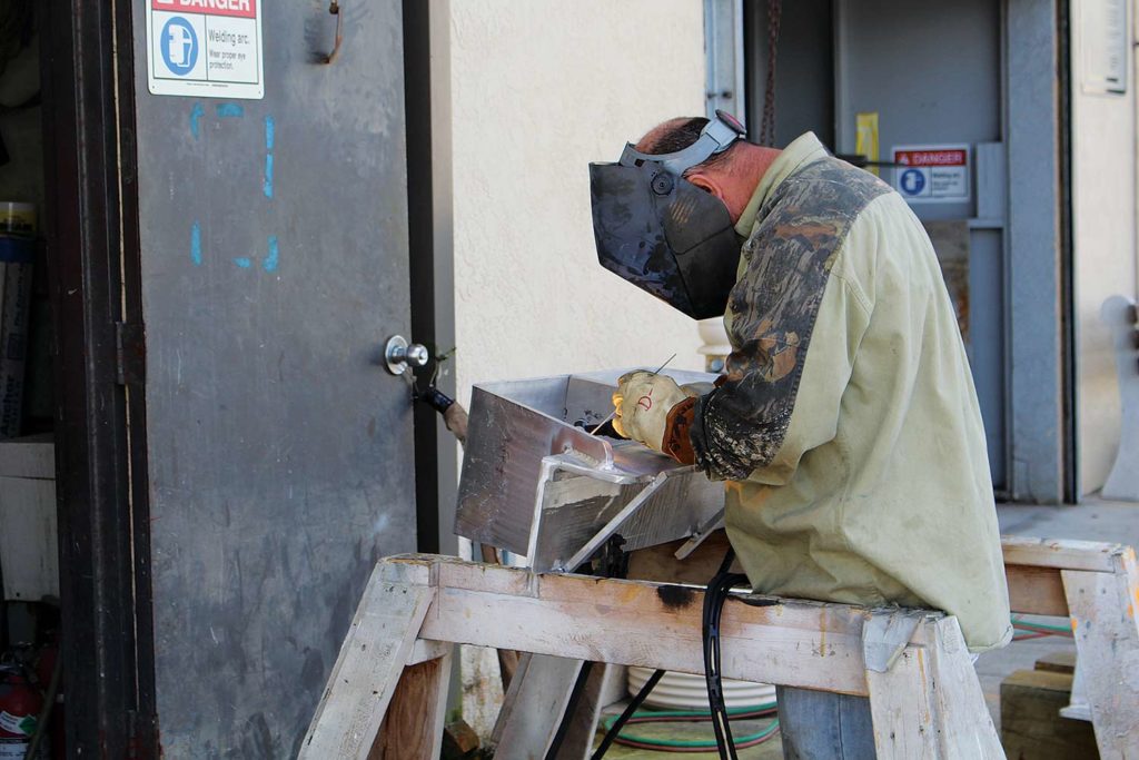 Worker repairing metal work for a boat repair.