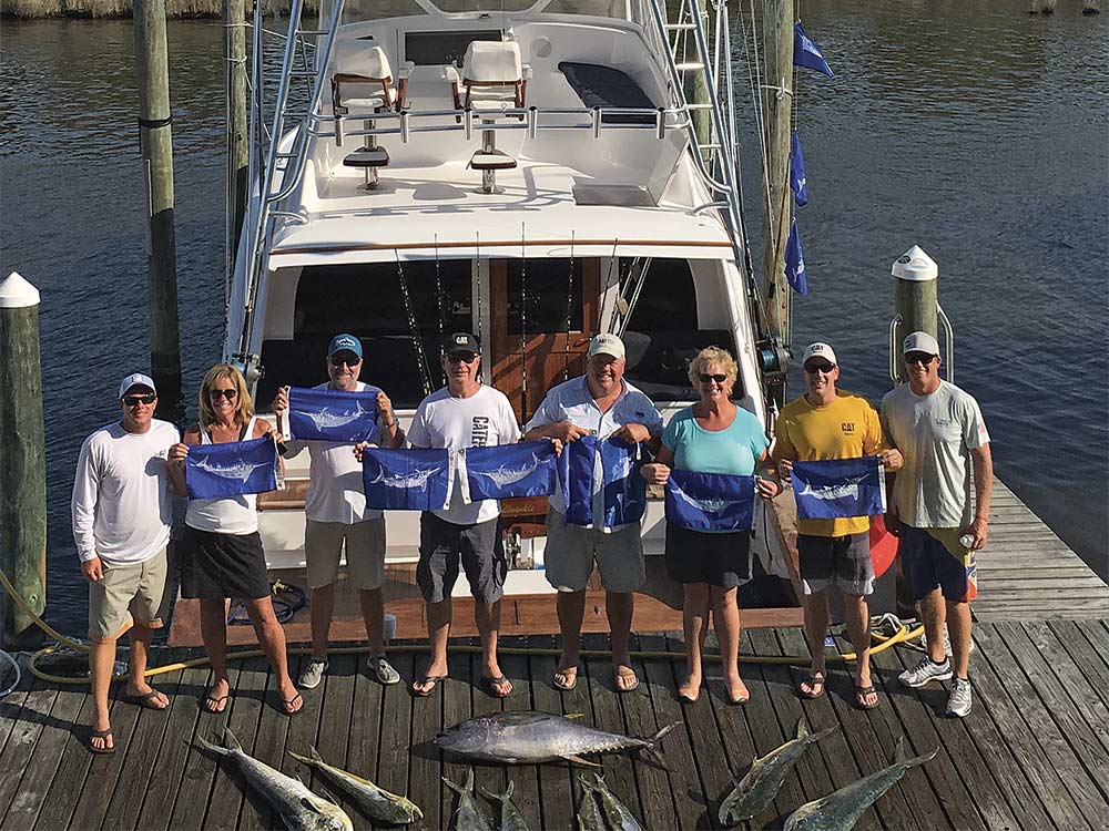 team holding up white marlin flags