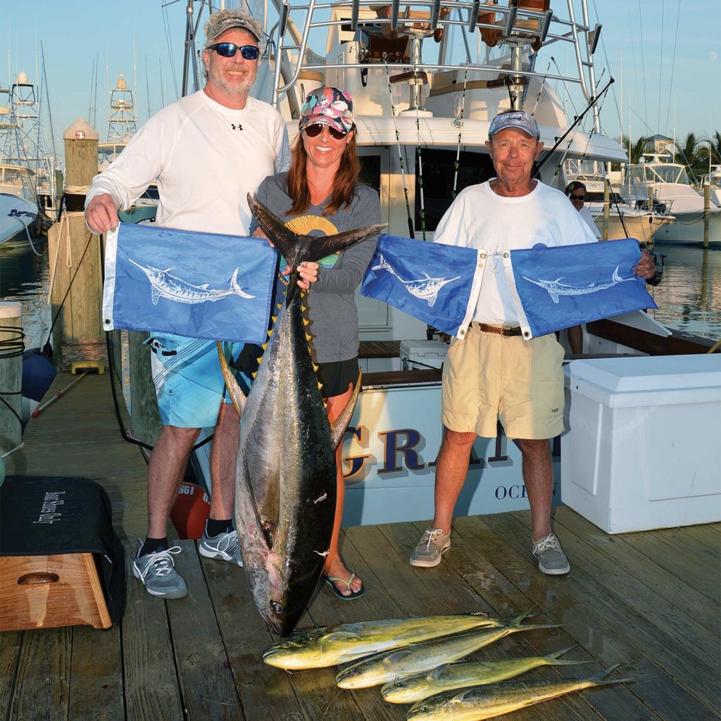 Anglers holding up white marlin flags.