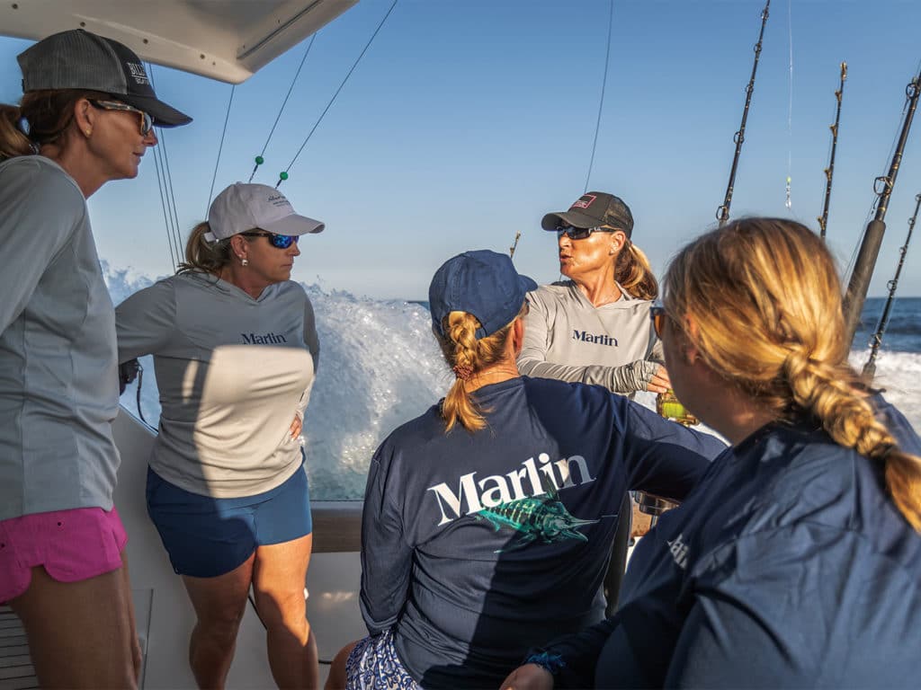 A team of women sport fishing on the ocean.