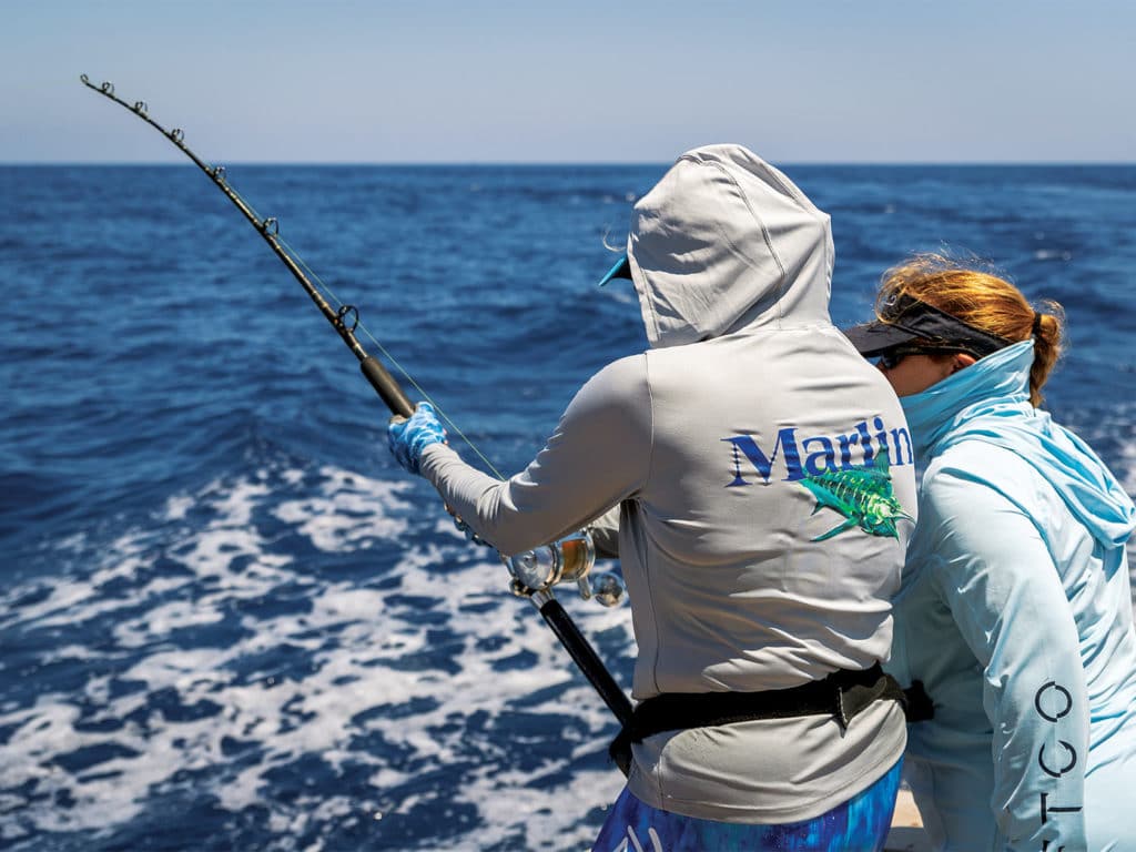 Two women sport fishing in the ocean.