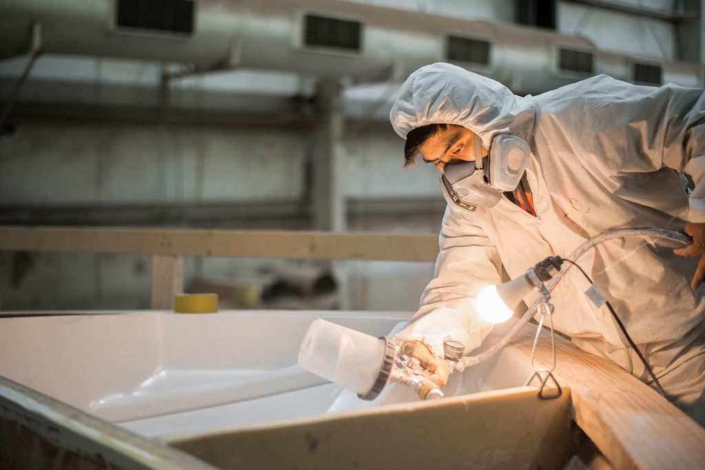 A boat dock worker repainting a boat helm.