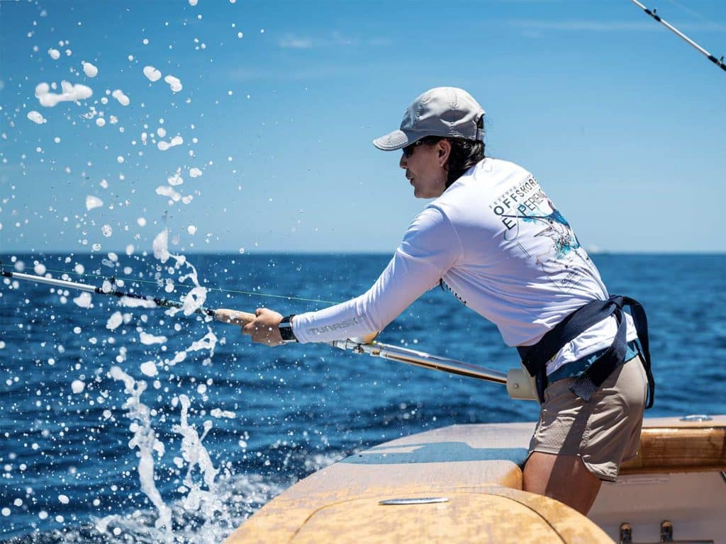 One woman fishing in the cockpit of a sport-fishing boat.