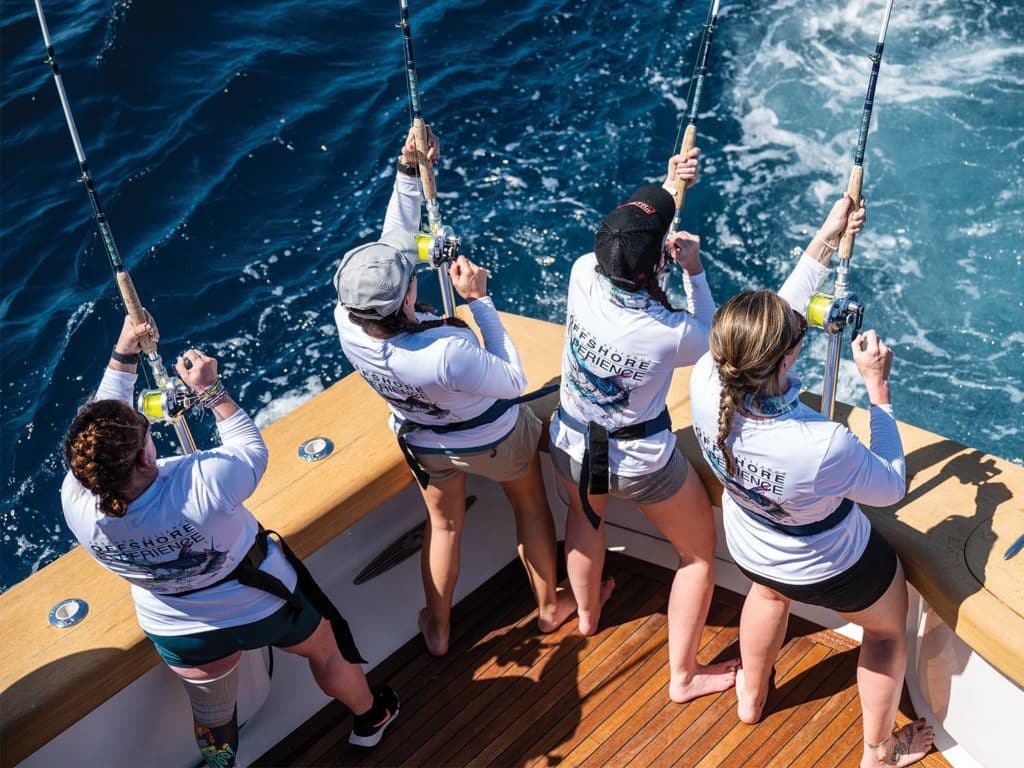Four women fishing in the cockpit of a sport-fishing boat.