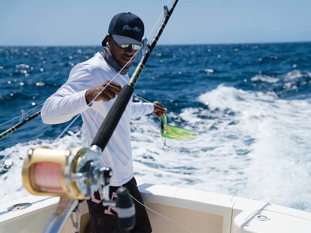 A crewman holding lures and hooks.