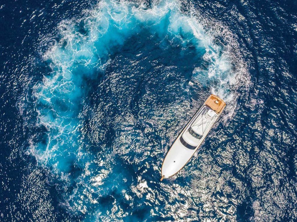 An aerial view of the Michael Rybovich & Sons sport-fishing boat making tight turns on the water.