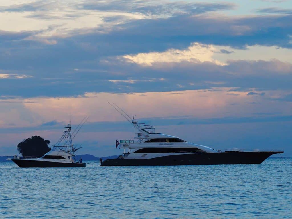 A sport-fishing boat and a yacht on the water.