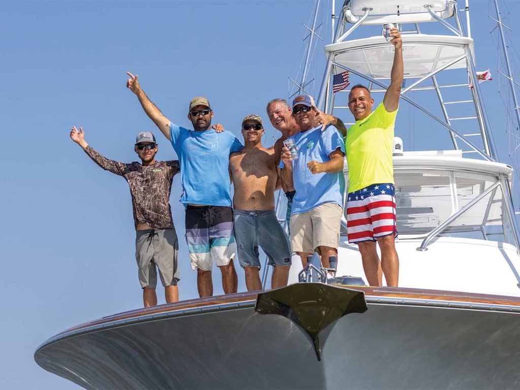 A sport-fishing team stands on the water.