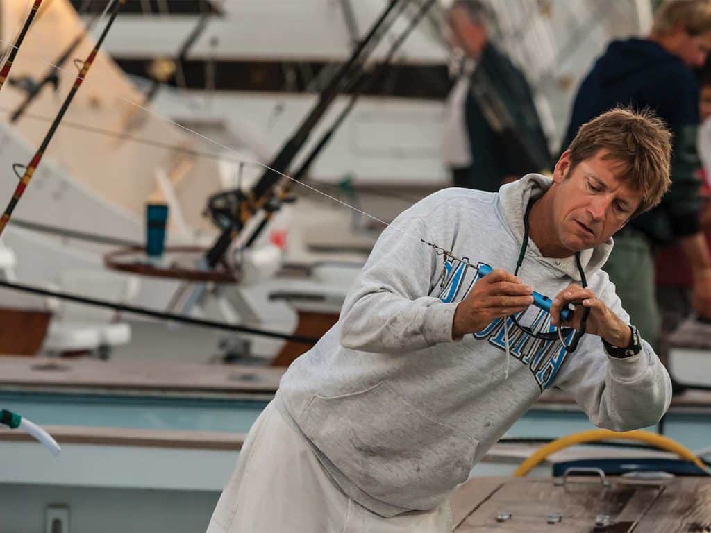 A boat captain working on the rigging.