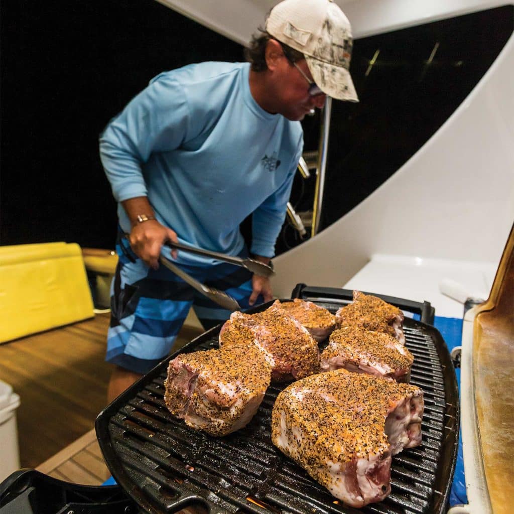 A man cooking at a grill.