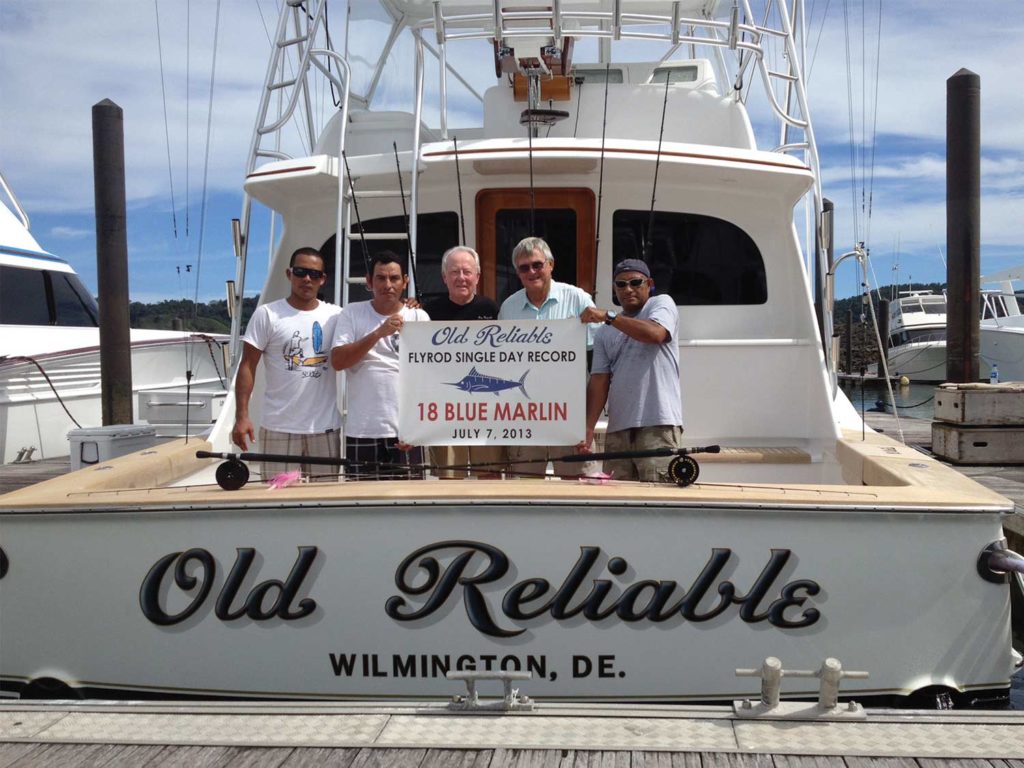 A group of anglers sitting on a boat deck.