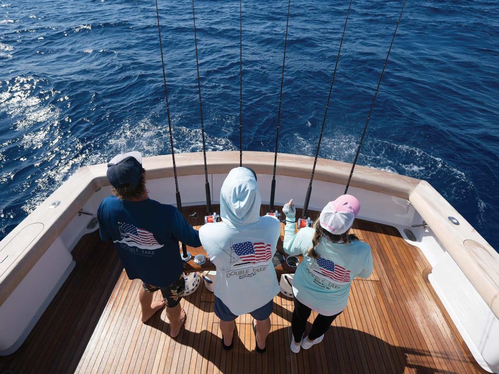 Three anglers on a boat fishing.