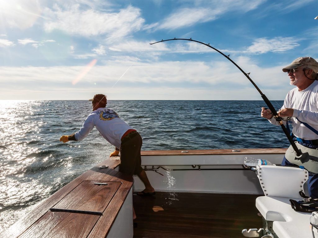 An angler and crewmate fighting a catch on the leader.