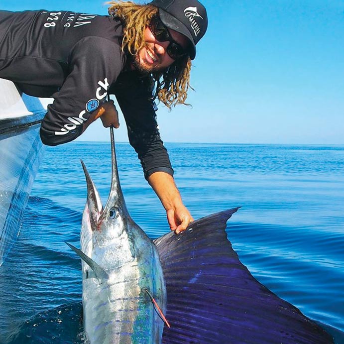 A sport-fishing angler holding a sailfish boatside.