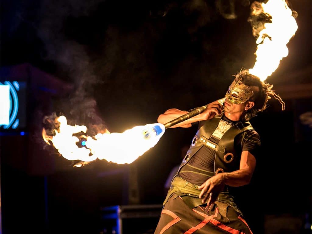 A fire dancer juggling a baton on fire.