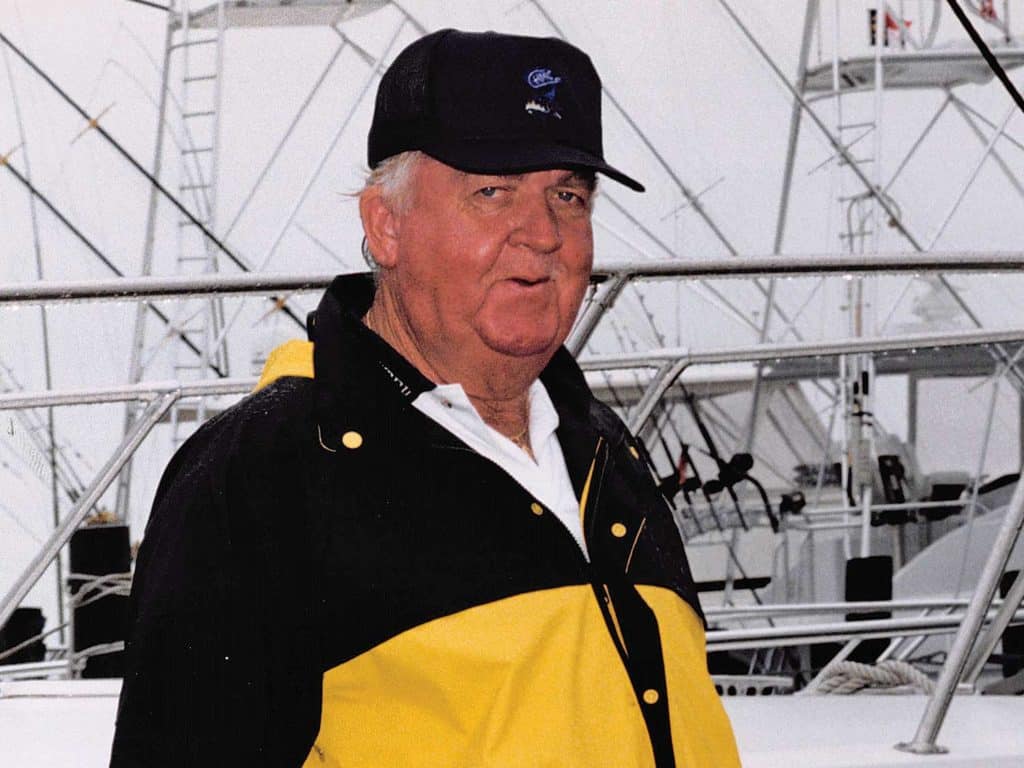 A portrait of a man in a black and yellow jacket.