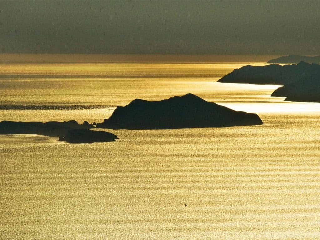 A series of islands in the water at sunset.