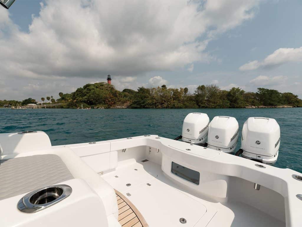 The cockpit of a sport-fishing boat showing a livewell and outboard engines.