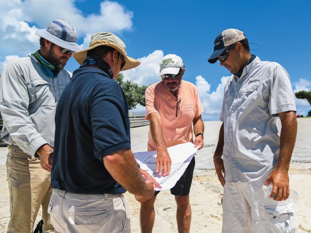 A group of men on a beach for a rebuilding meeting.