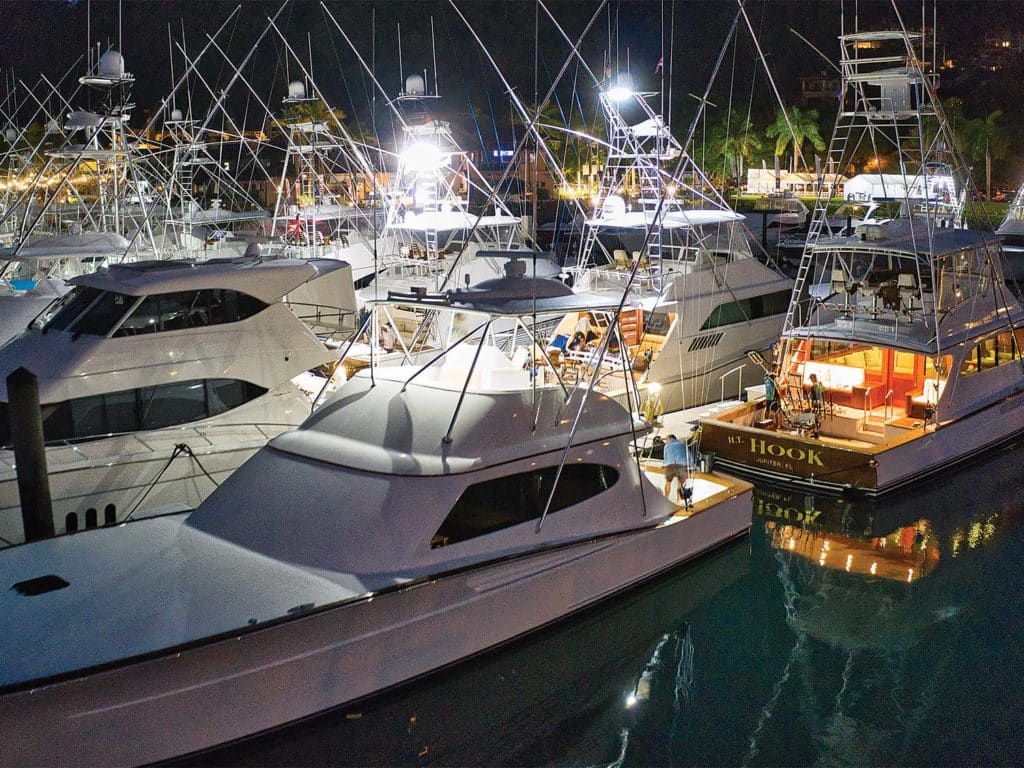 Sport-fishing yachts docked in a marina at night.
