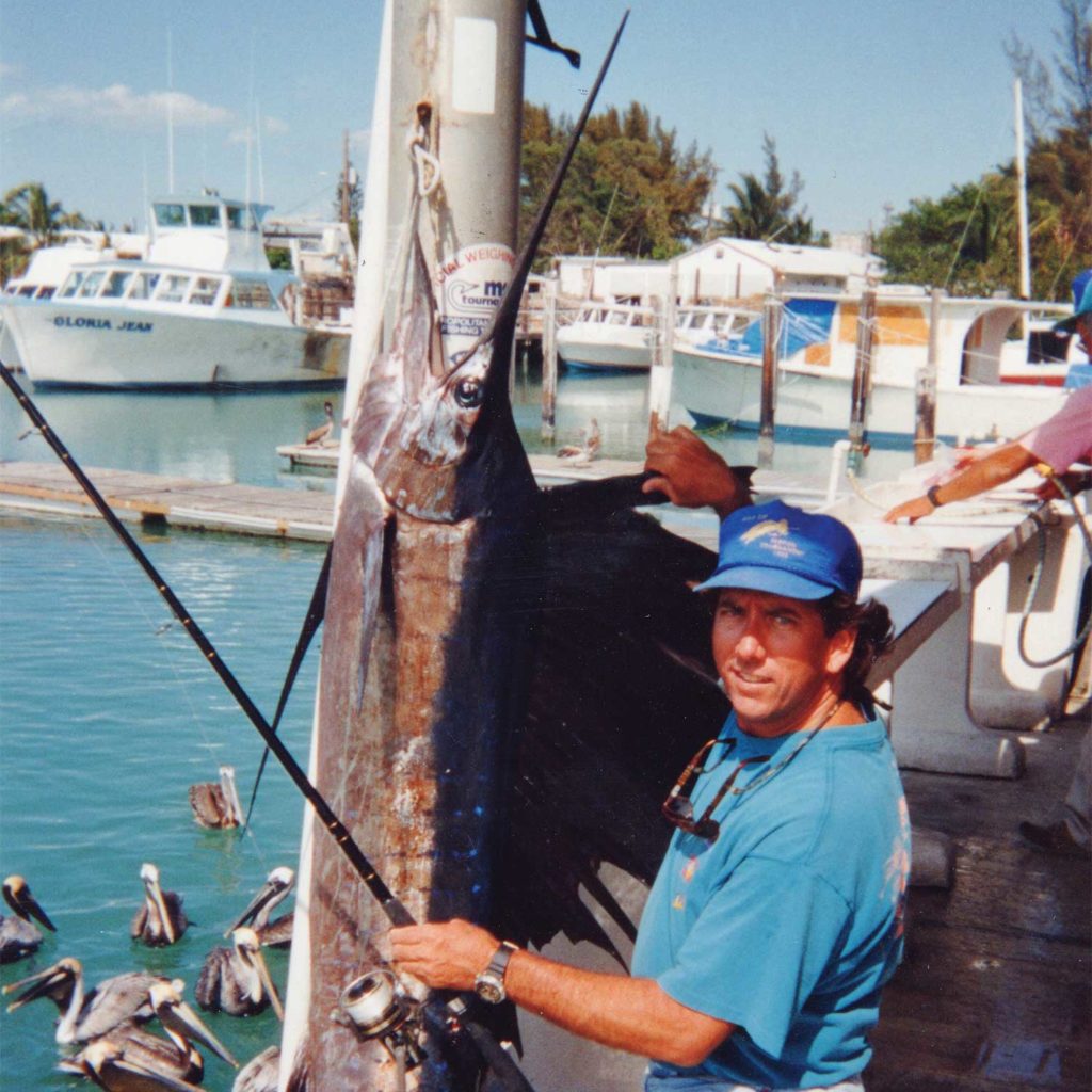 A man standing next to a large Atlantic sailfish.