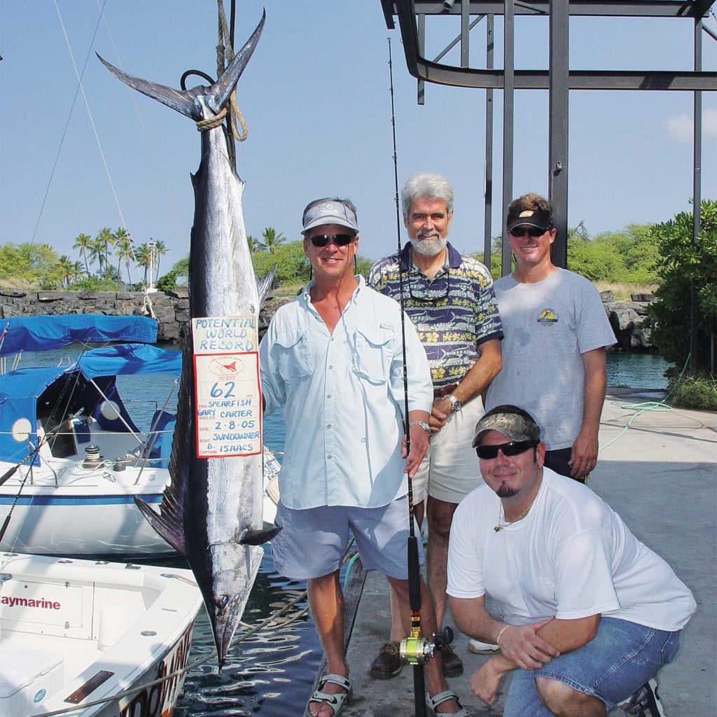 A fishing team stands next to a large shortbill spearfish.