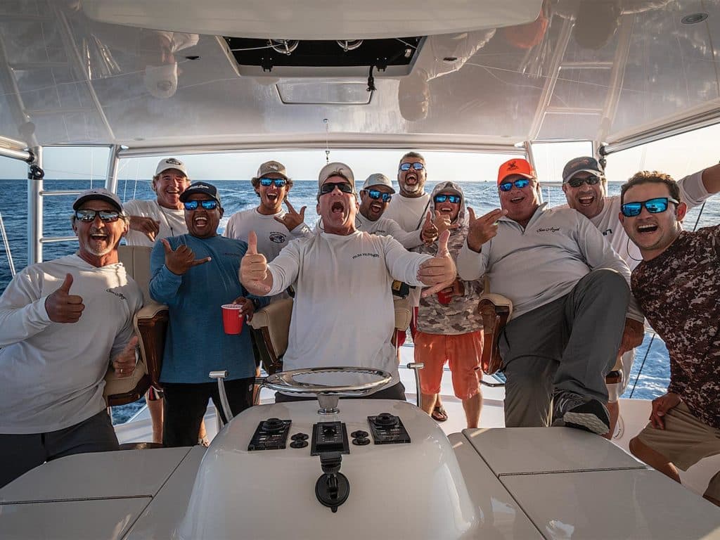 Team Rum Runner celebrating at the helm of a sport-fishing boat.