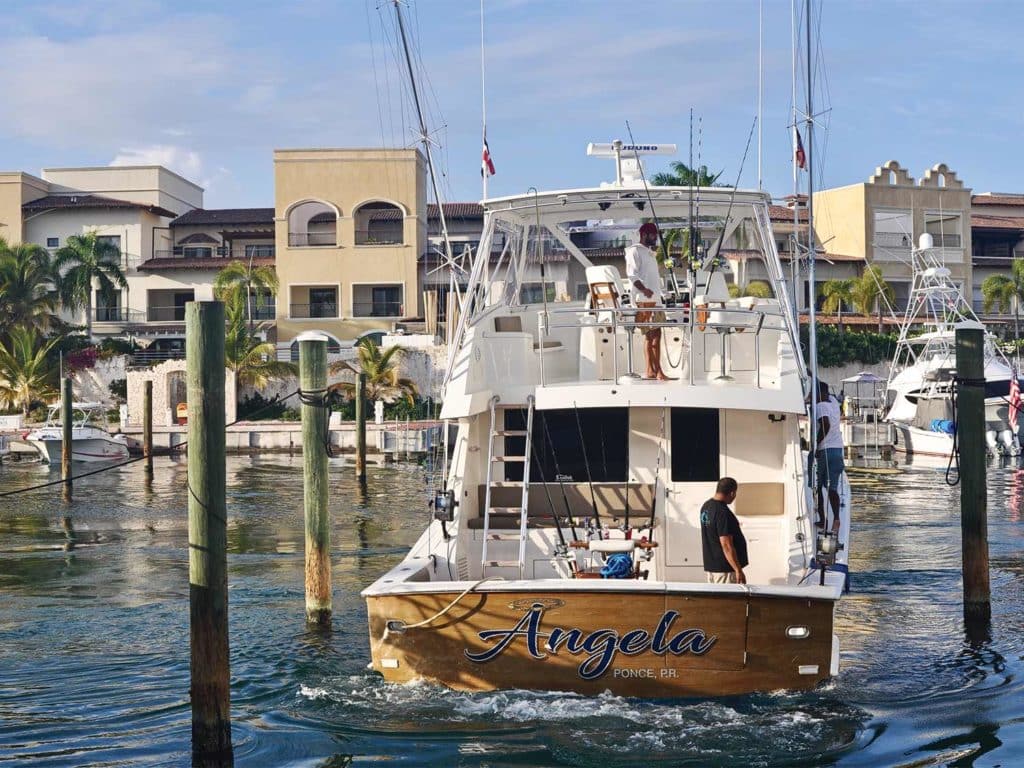The transom view of a sport-fishing boat with a city in the background.
