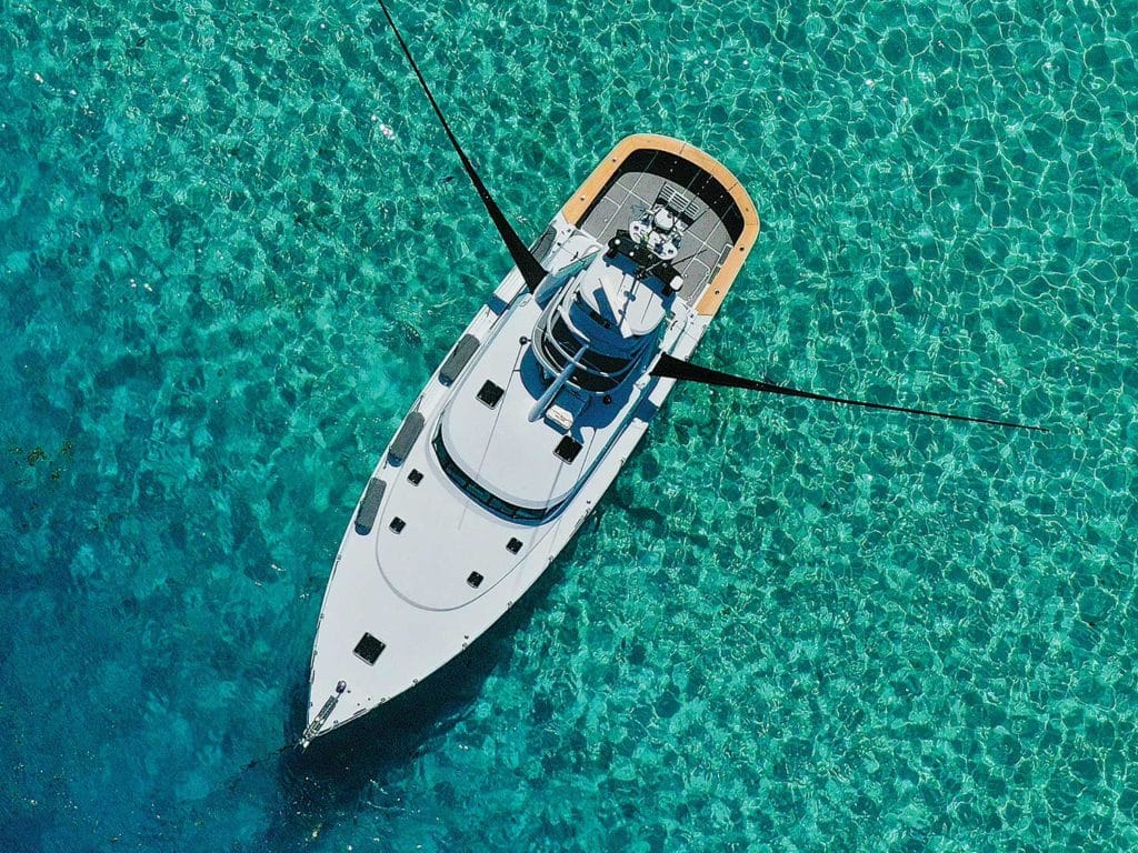 Top-down aerial view of a sport-fishing boat at sea, showing its equipment deployed.