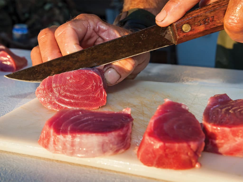 A tuna being sliced into steaks