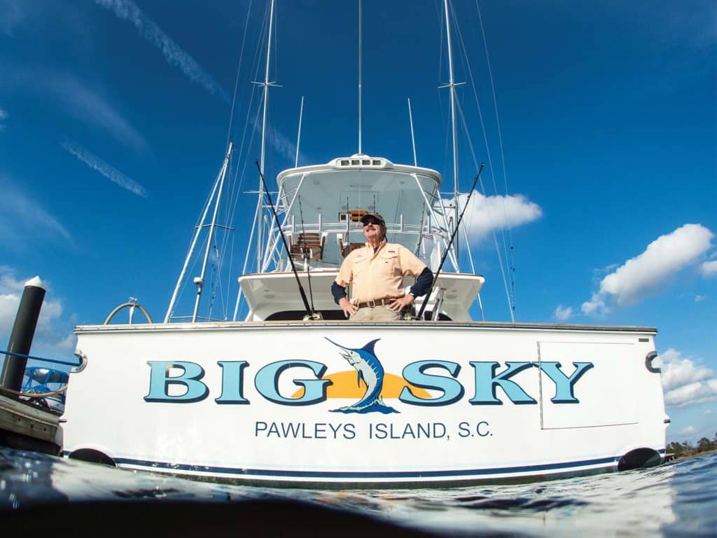 The rear transom of a sport-fishing boat, with the words Big Sky painted on.