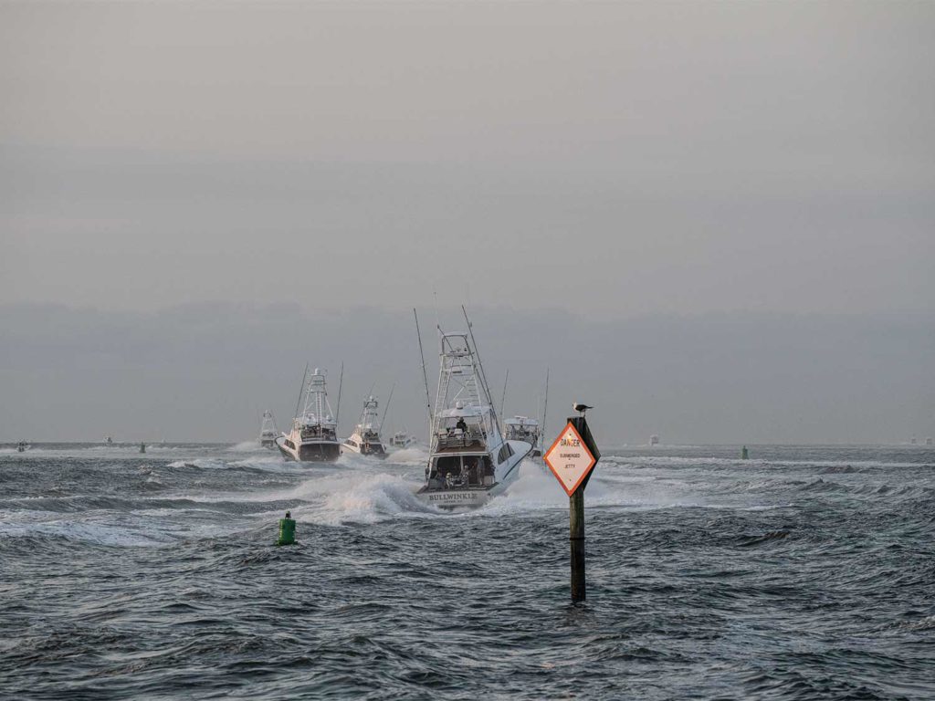 A fleet of boats piloting over dangerous waters.