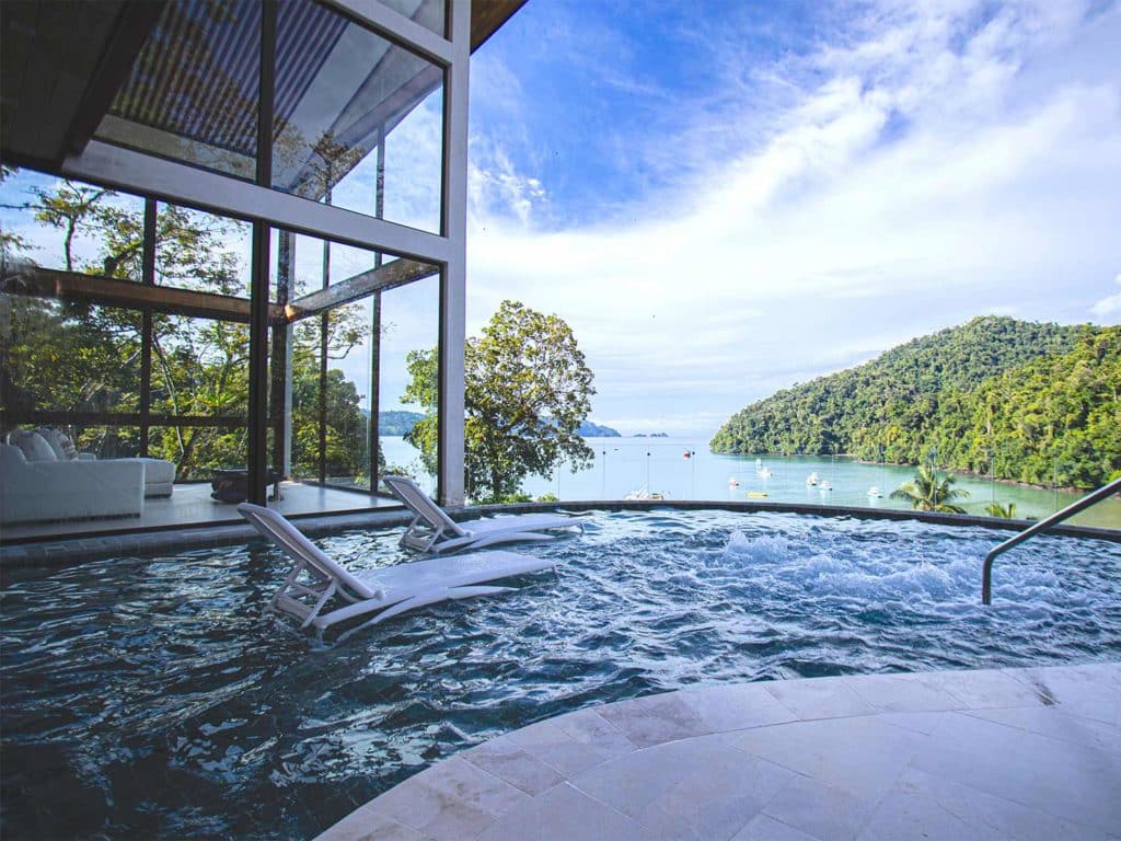 A relaxing lounge pool and spa overlooking a bay.