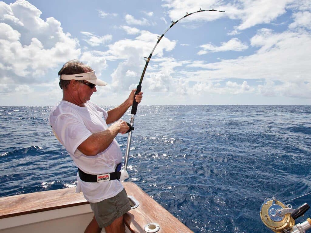 A sport-fishing angler reeling in a large fish.