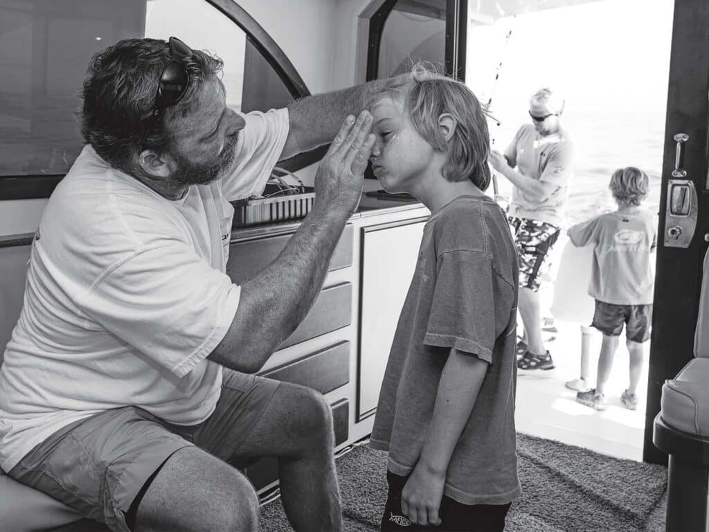 An adult applying sunscreen to a small child.