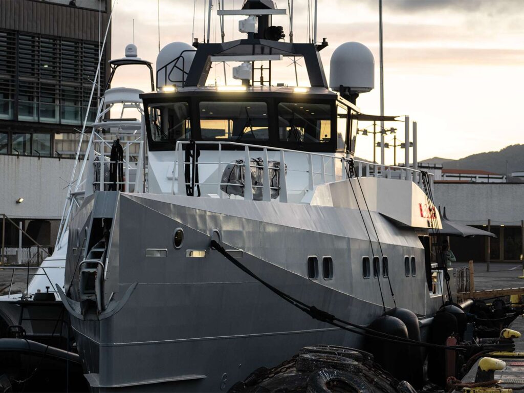 A large mothership yacht docked in a marina.