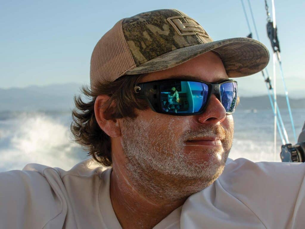 A sport-fisher wearing sunglasses and a hat while wearing mineral-based sunscreen.