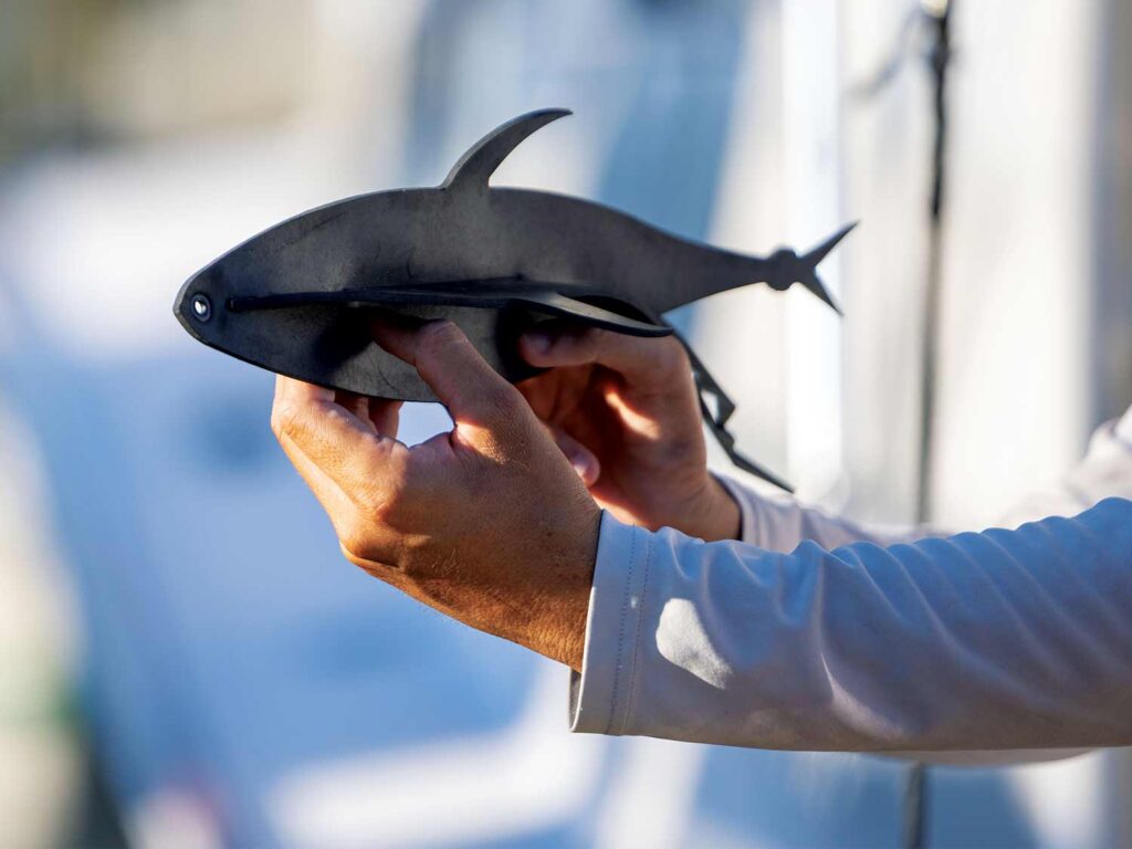 Two hands holding up a small tuna dredge crafted to be three-dimensional