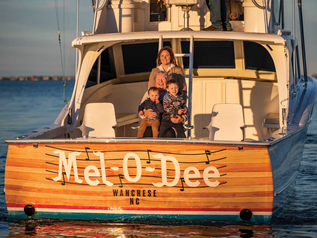 A family standing in the cockpit of a sport-fishing boat.
