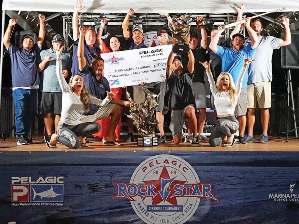 A sport-fishing team standing on a stage during a fishing tournament awards ceremony.