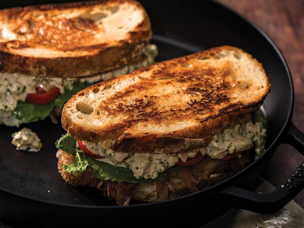 Two toasted wahoo melts prepared in a cast-iron skillet.